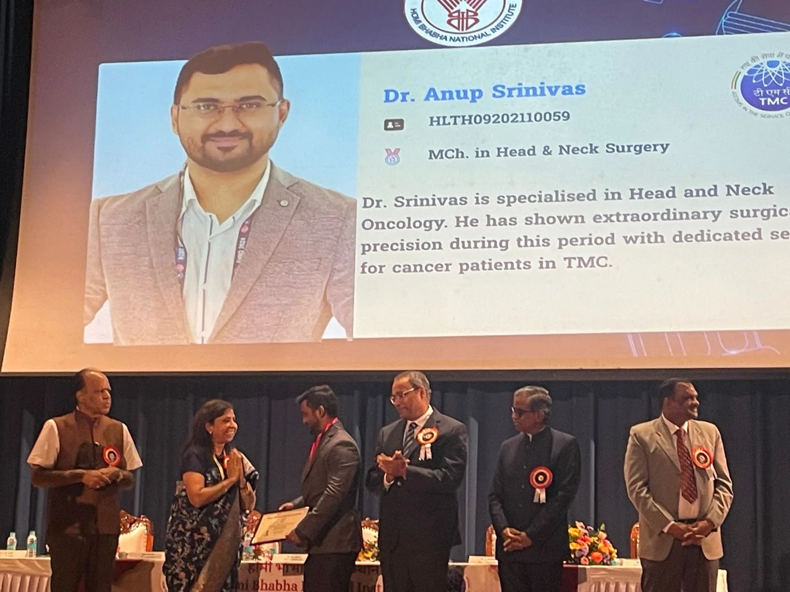 Dr Anup Srinivas receiving an award on stage